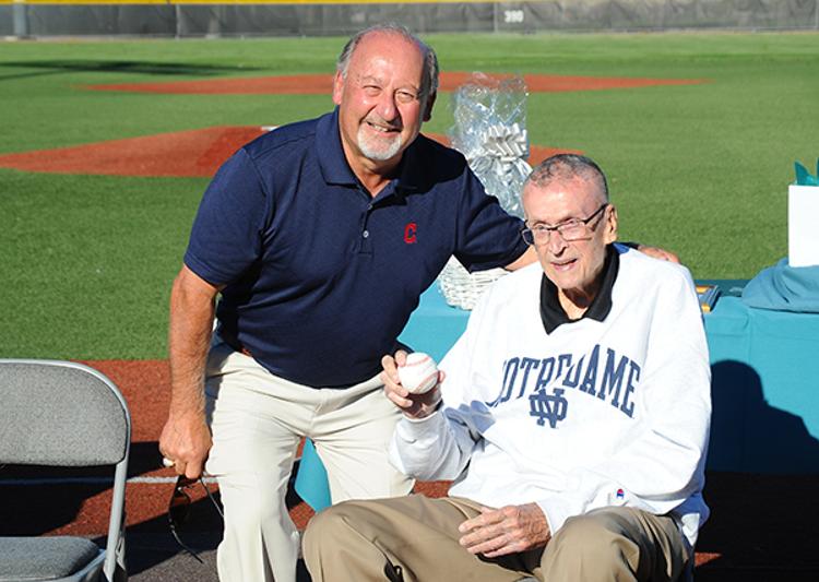 Bob DiBiasio of the Cleveland Indians presents Ron Mottl with a baseball signed by Indians legend Bob Feller.
