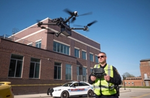 Person flying drone with police cruiser in background