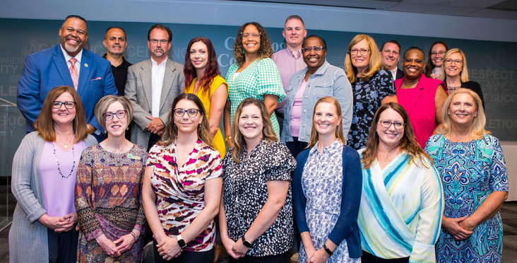 Photo of 19 individuals standing onstage