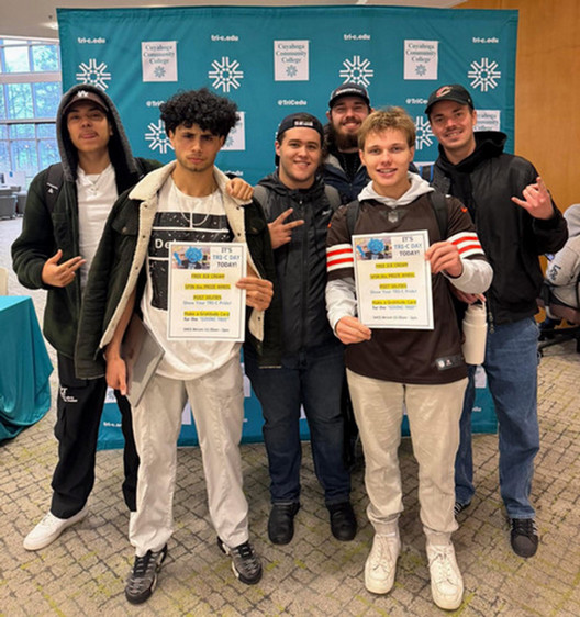 Male students grouped and holding small posters