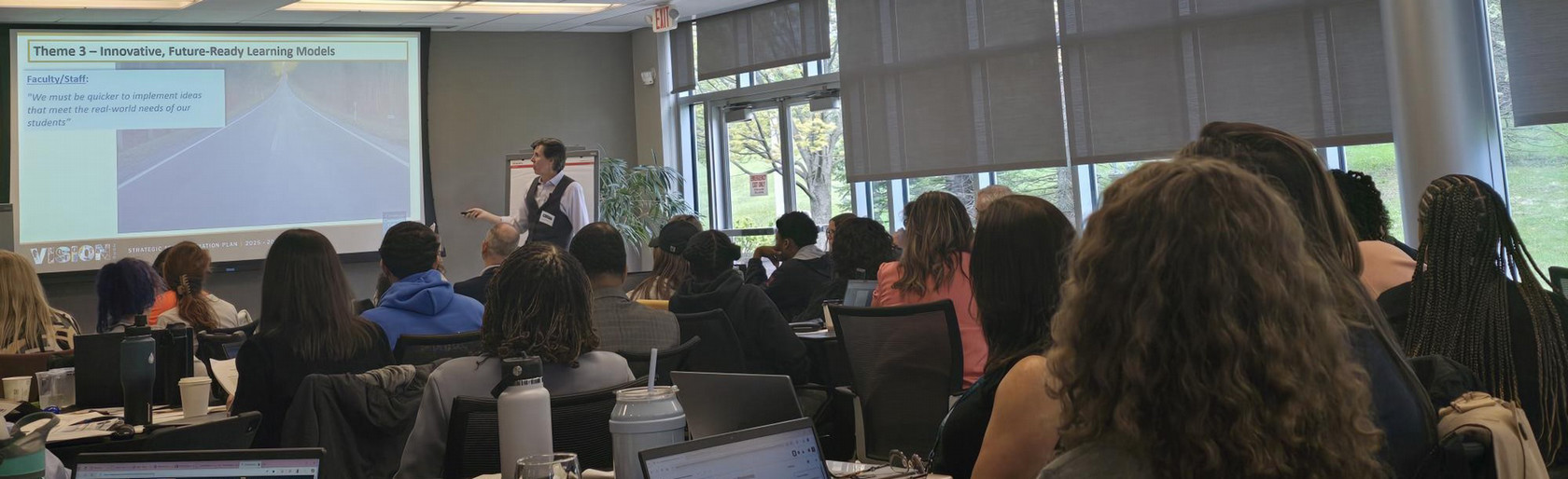 Photo of person presenting in front of group of people