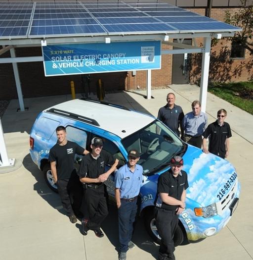 Automotive Technology students in front of the program's solar panels and electric vehicle charging station