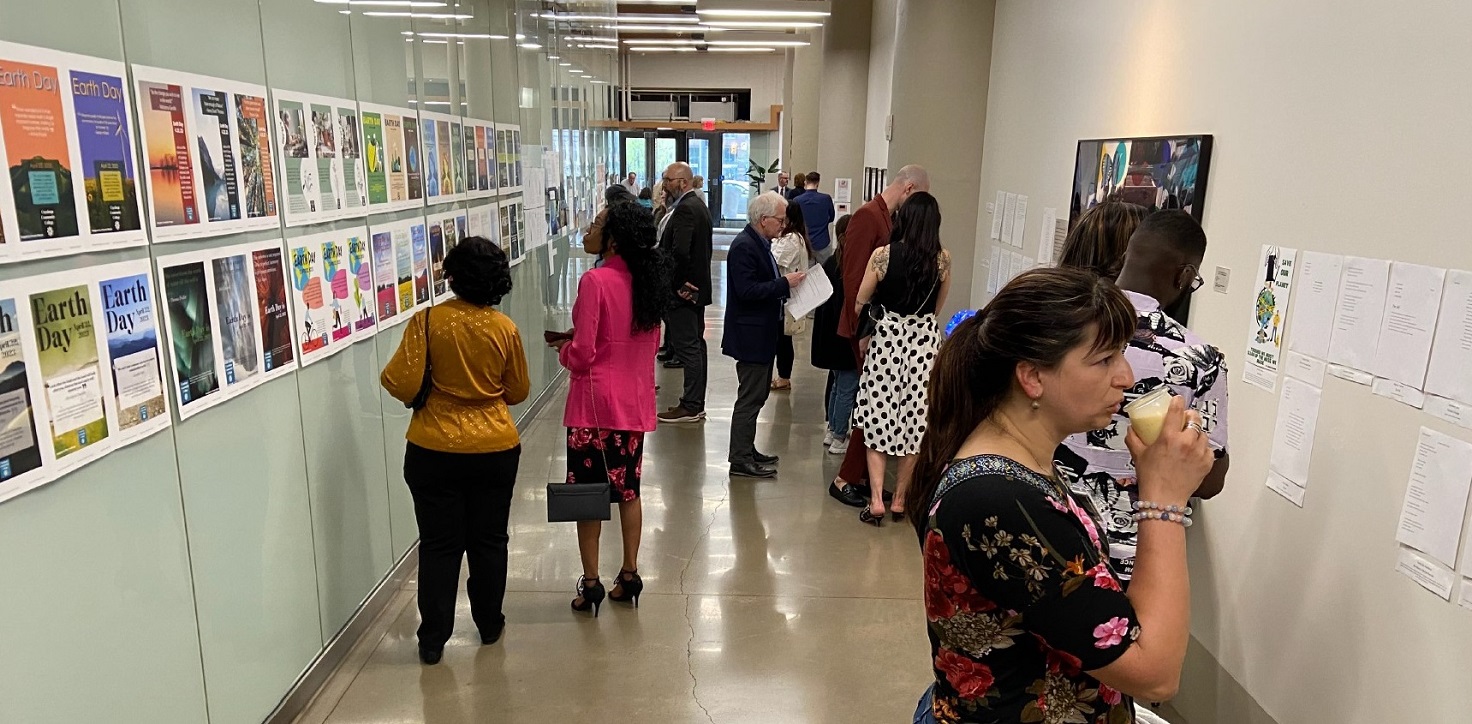 Metamorphosis Cleveland 2023 event attendees looking at a gallery of student submissions
