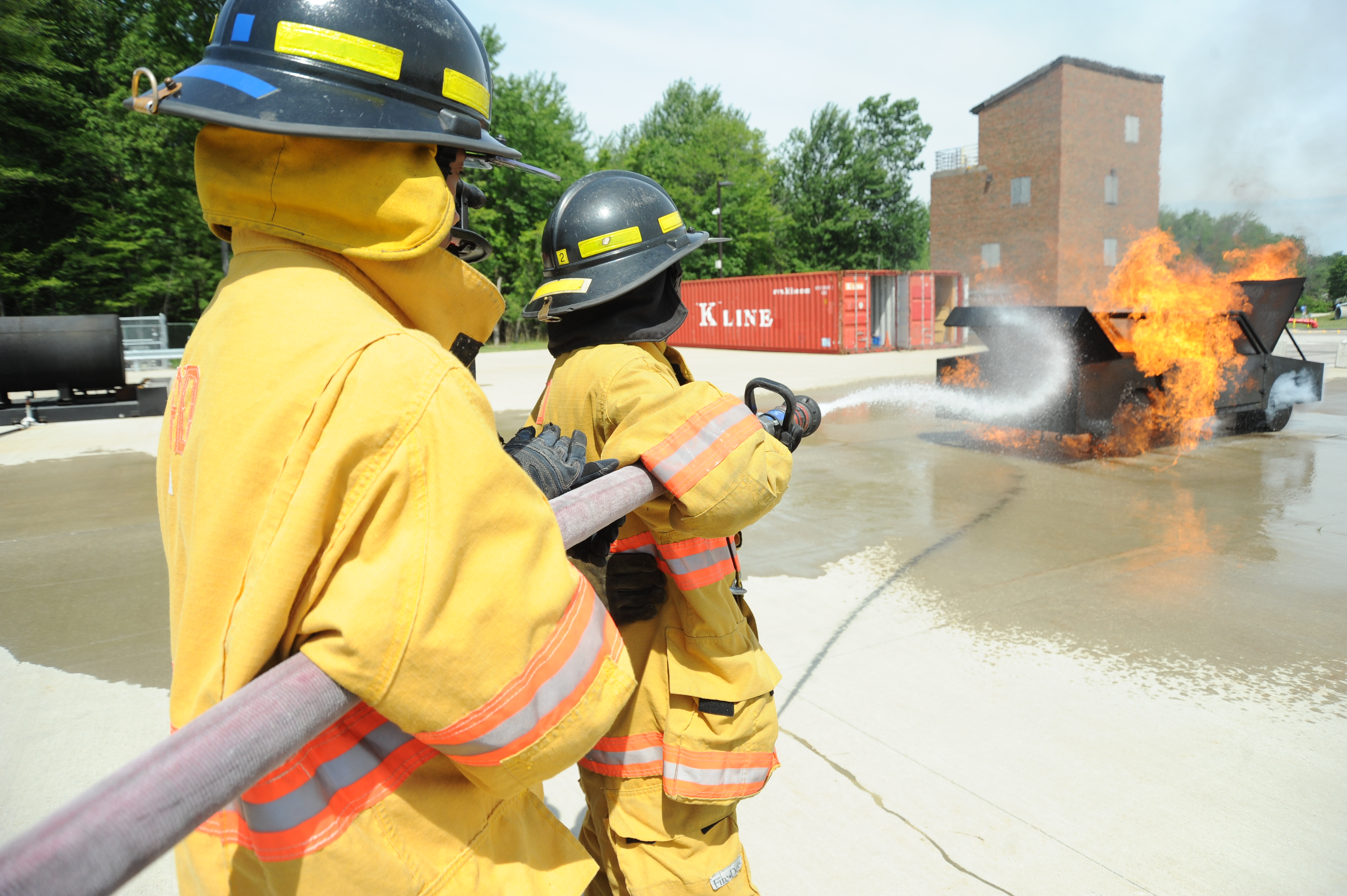 Pictures of students using fire hose to put out fire