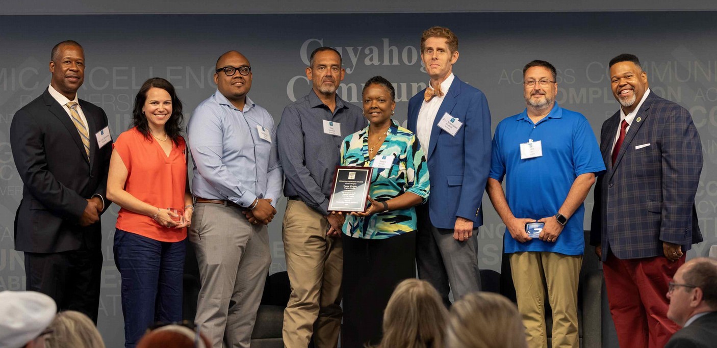 Photo of 8 individuals holding award