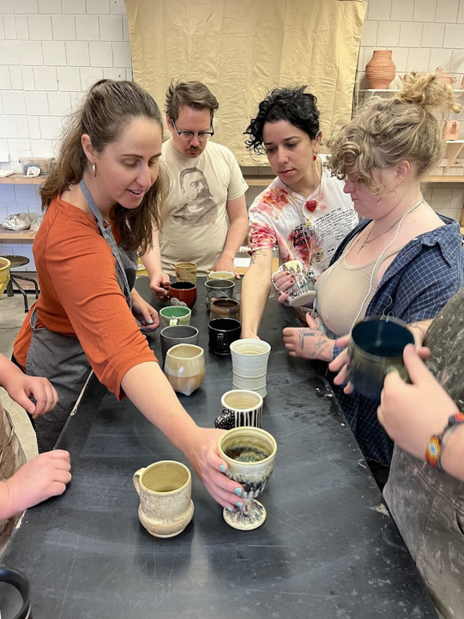 students showing ceramics