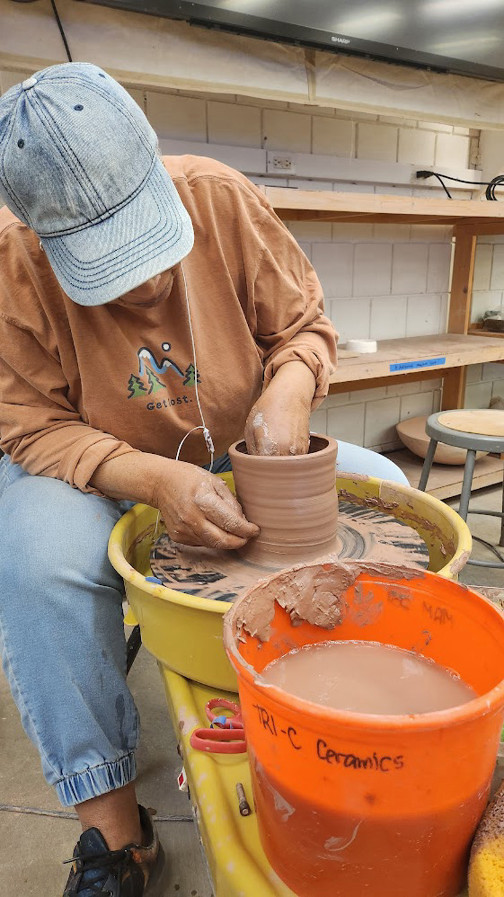 student at pottery wheel