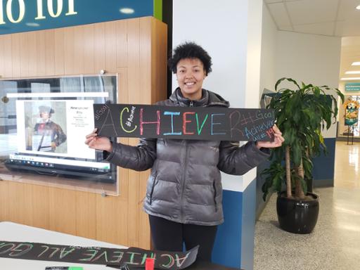 Student holding achiever sign