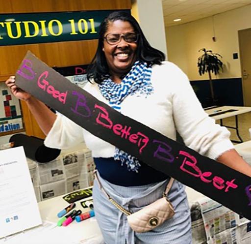 Student holding a Be Best sign