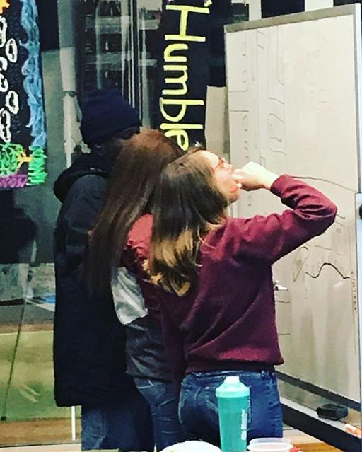 Three students at a dry-erase board