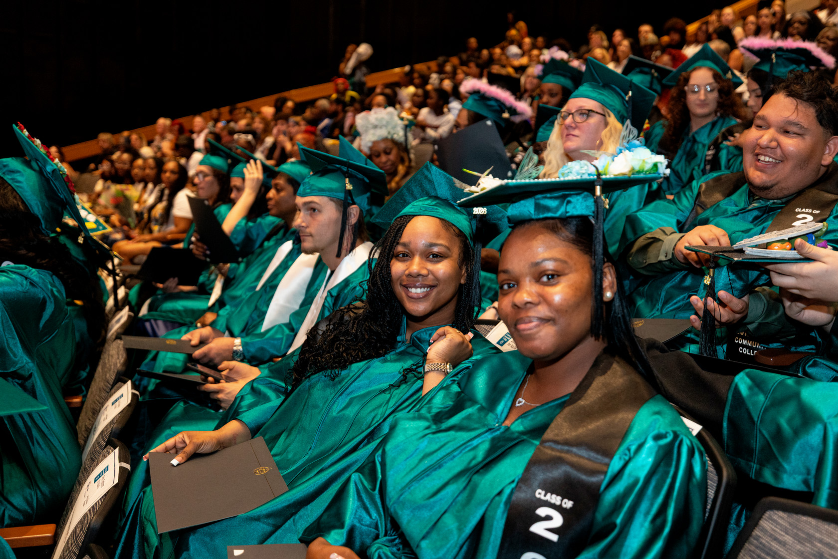 Graduates sitting in the stands expressing excitement
