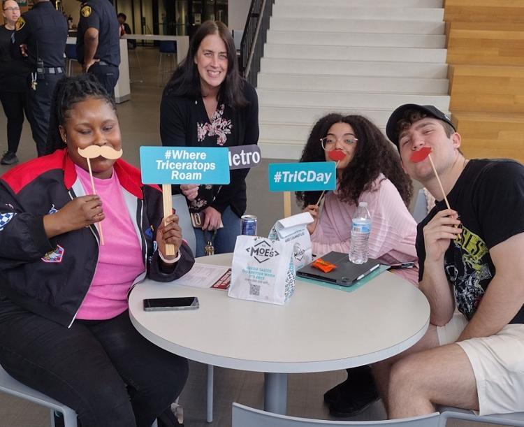 Students around a table with selfie props