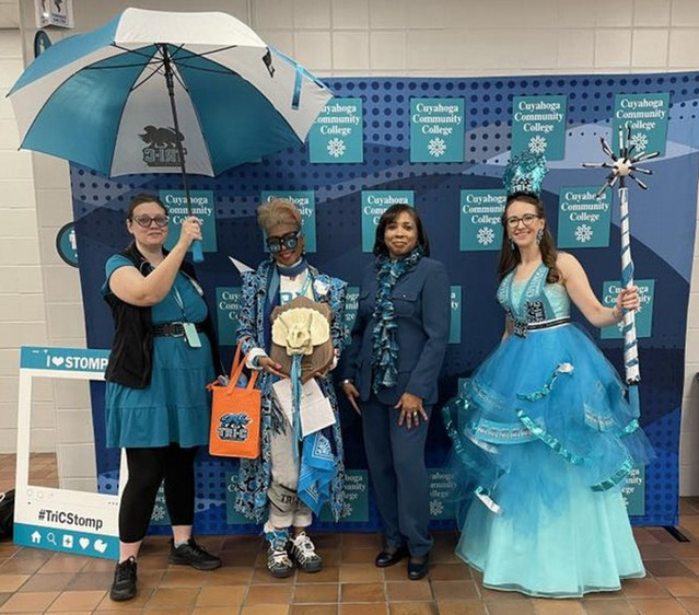 Students, smiling with selfie props, wearing costumes made of Tri-C swag