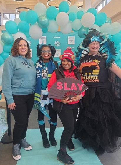 Students, smiling with selfie props, wearing costumes made of Tri-C swag