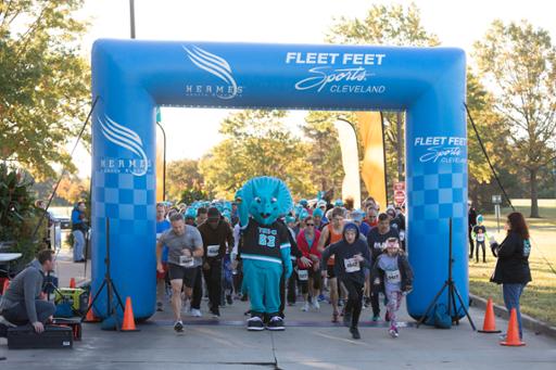Stomp the Triceratops and runners at the Autumn Blaze 5K starting line