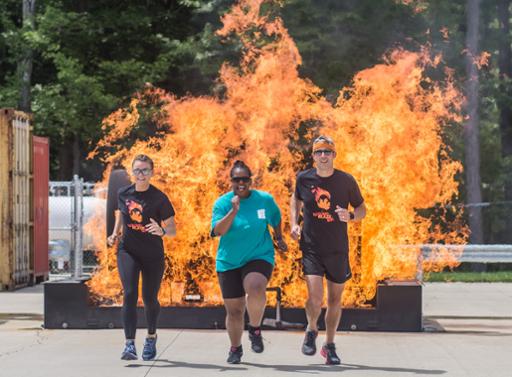 Three runners in front of a fire simulator