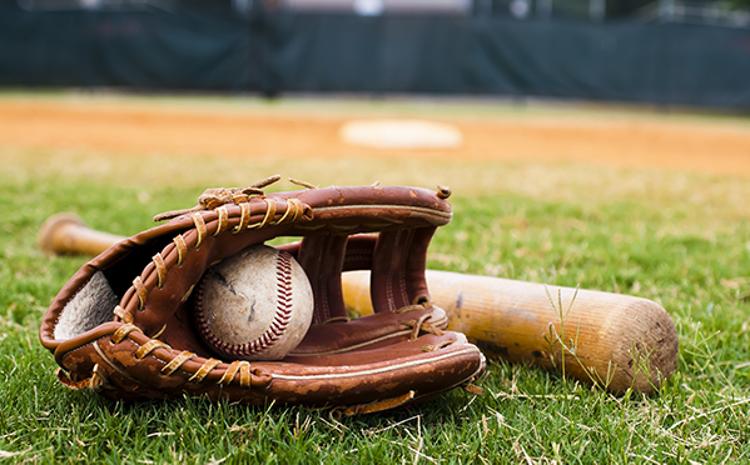 Baseball bat, ball and glove sitting on a grass field