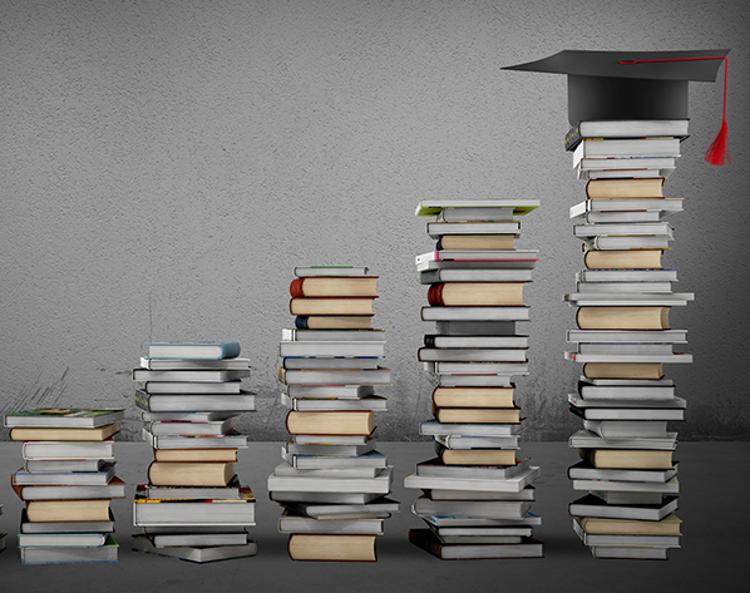 Stacks of books leading upward to a graduation cap