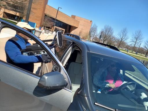 Tri-C staff member loading a computer into a student's car.