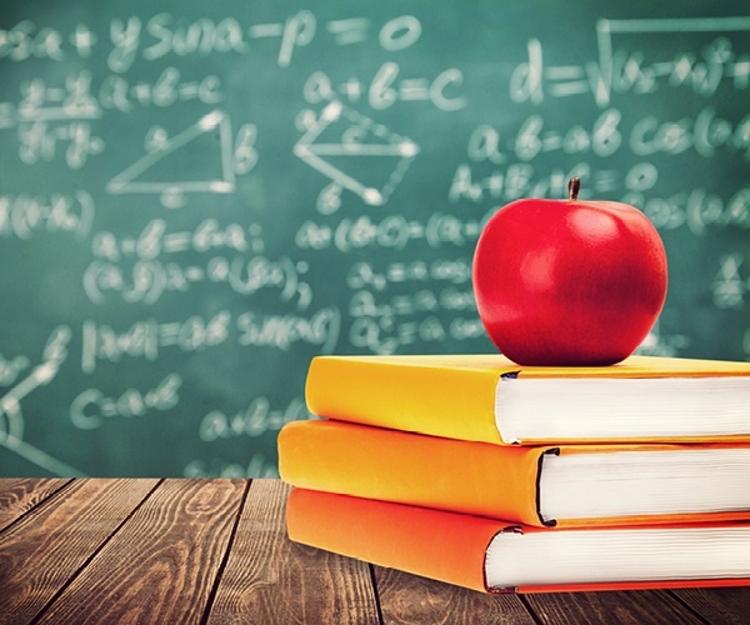 Apple and books in front of chalkboard