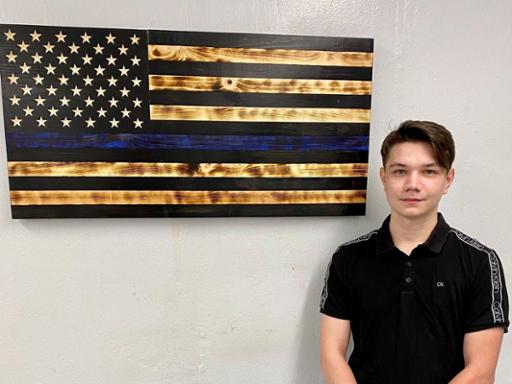 Leo Negomedzyanov with the wooden 'thin blue line' flag he donated to North Royalton police