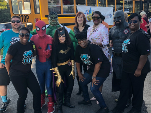 Group shot of Tri-C staff with costumed super heroes at the Fox 8 "Stuff the Bus" drive