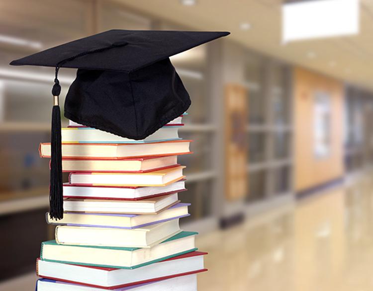 Graduation cap sitting on top of a stack of books