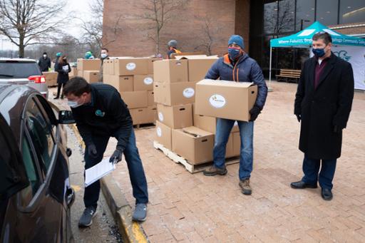 Volunteers loading boxes of food into cars at Western Campus