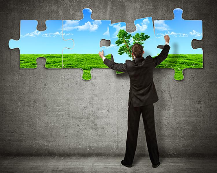 Businessman placing large puzzle piece in a nature scene