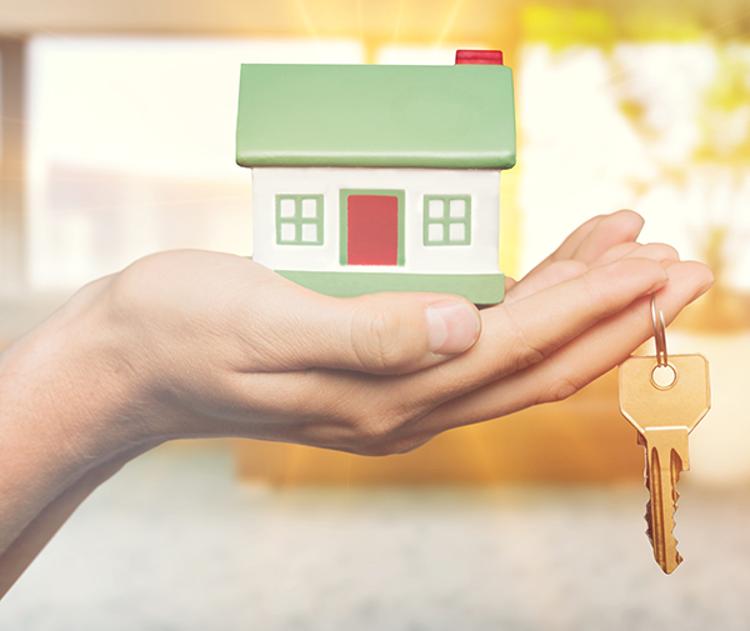 Hand holding small model house and key