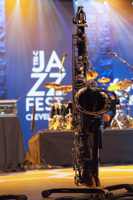 Saxophone on a stand with JazzFest logo in background