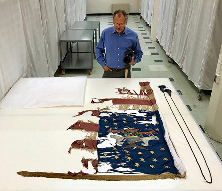Daniel Levin looks at the flag of the 74th Pennsylvania Volunteer Infantry, a Civil War regiment in which his great-great-grandfather served.