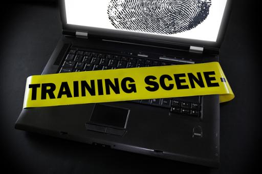Computer with police tape across keyboard with the words "Training Scene"