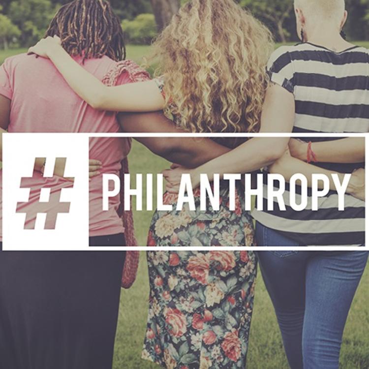 Women walking arm-in-arm with philanthropy hashtag overlay