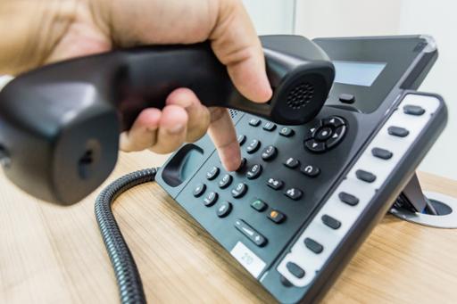 Person's hand dialing a phone number