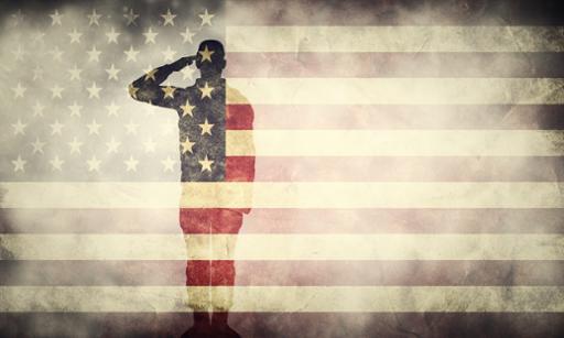 Saluting soldier in front of a flag