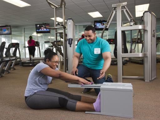 A Tri-C student training a client in a workout room