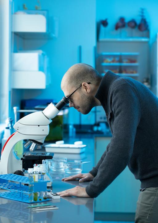 Tri-C student looking through a microscope