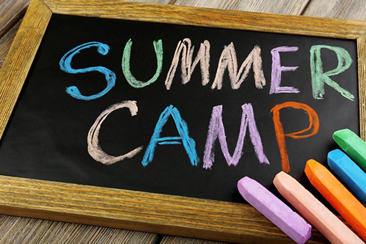 Chalkboard with "summer camp" written in multicolored chalk
