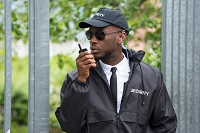 African-American, male security guard talking on radio