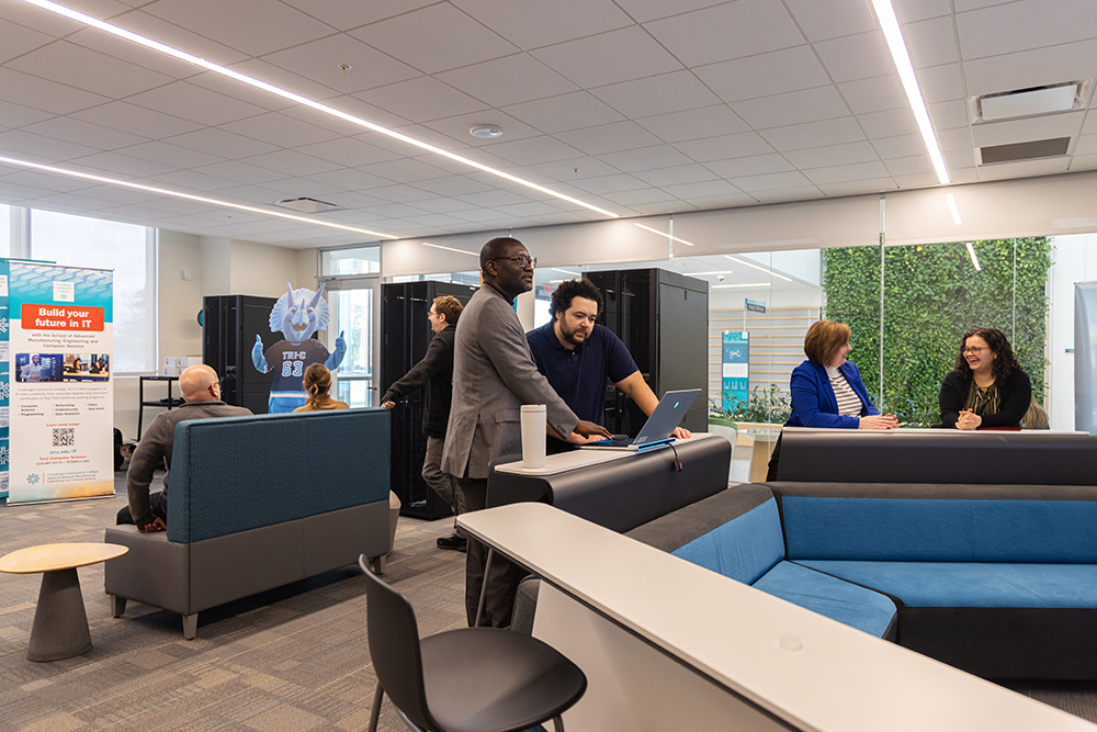 Photo of people engaging in conversation in the Cybersecurity Defense Center