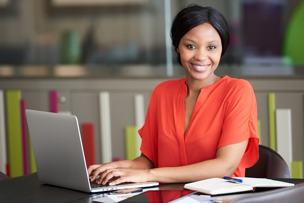 Woman typing on computer smiling