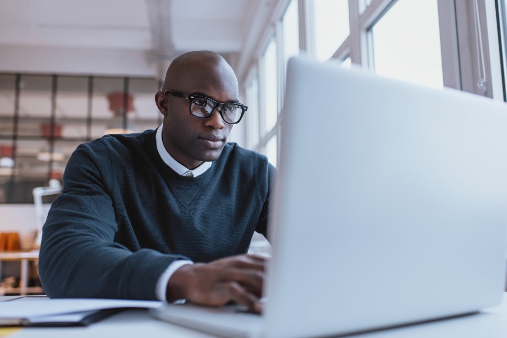 Picture of man sitting in front of laptop computer.