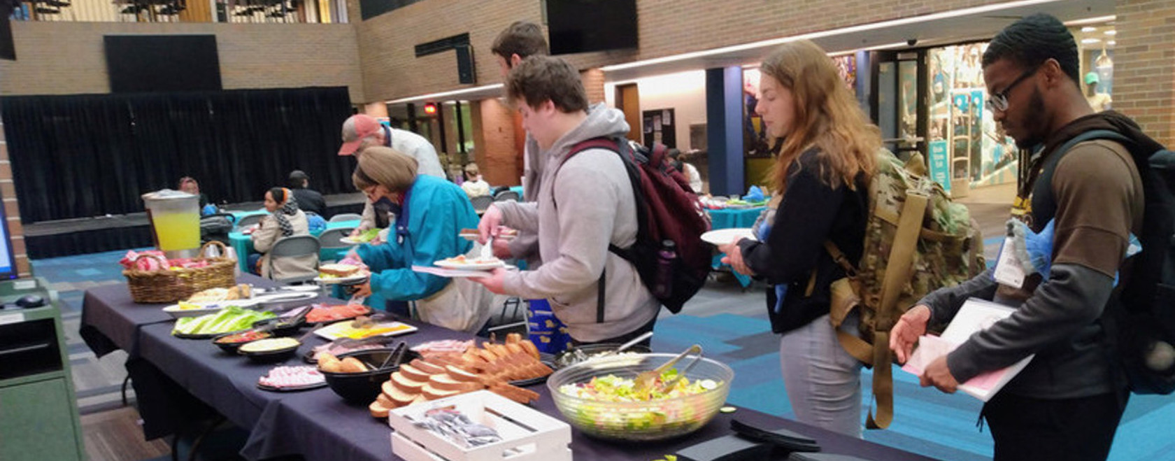 Students in line making their own sandwiches for lunch during event