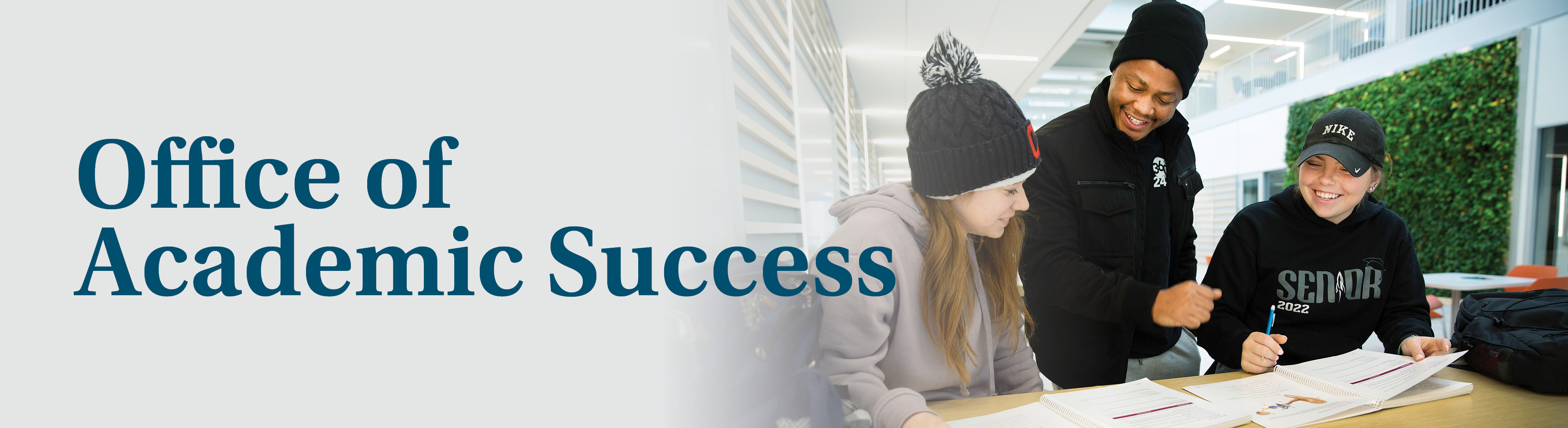 Two students smile as they work with a Tri-C employee