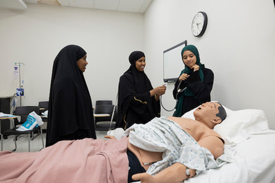 group of students practicing on a cpr dummy