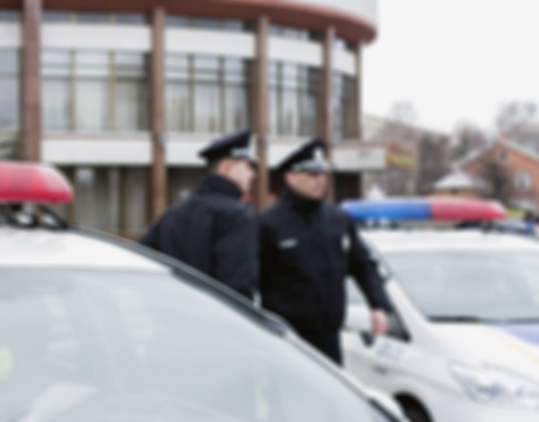 Blurred picture of two police officers walking by vehicle